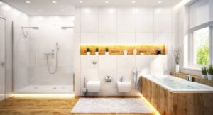 Contemporary bathroom featuring white tile walls, wooden vanity, freestanding bathtub, walk-in shower, and illuminated wooden shelf with decorative plants.