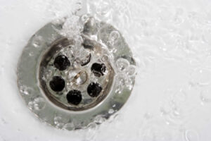 Water pouring from a damaged ceiling outlet surrounded by wet drywall and water stains.